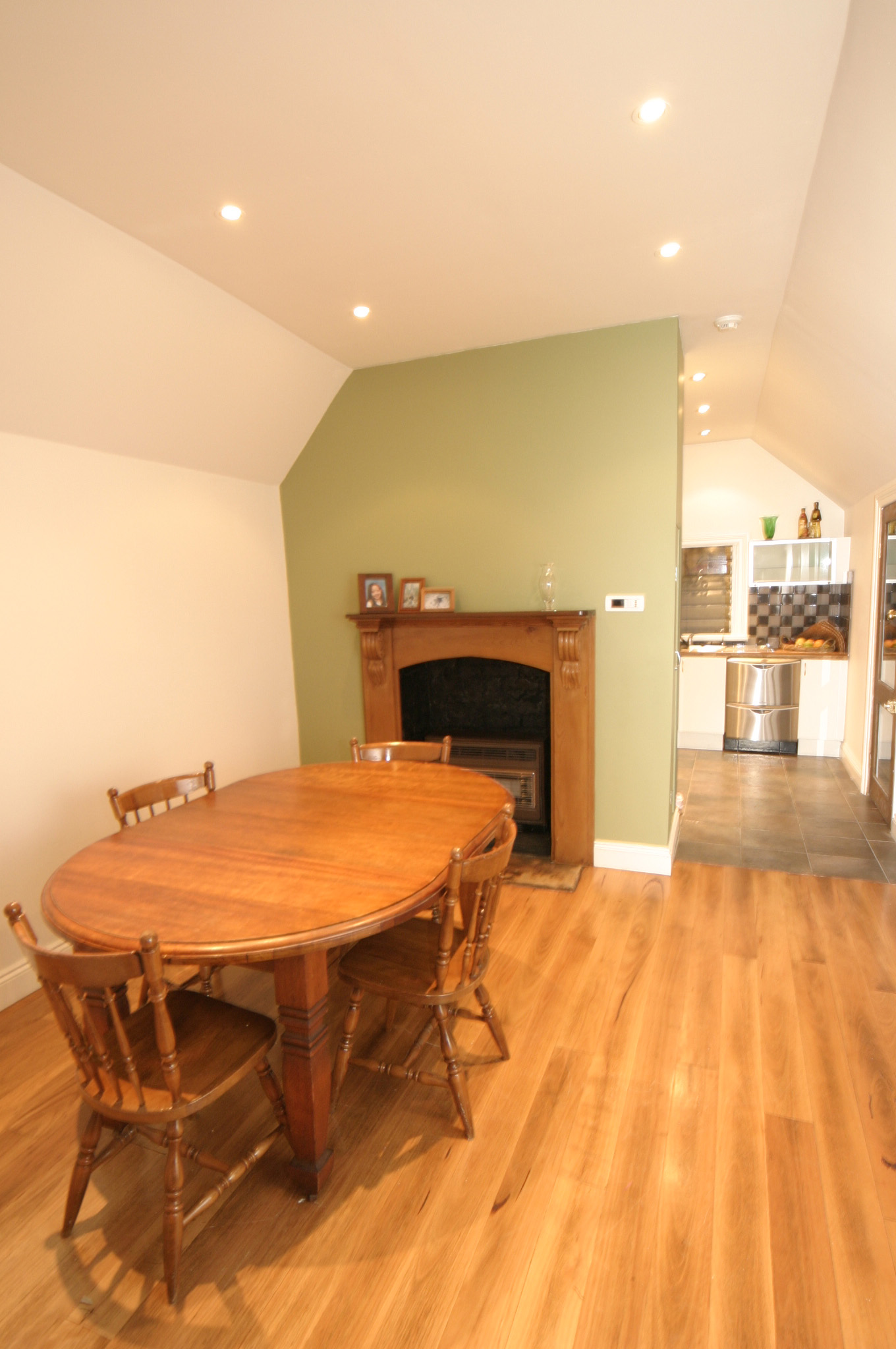 Dining area looking towards kitchen with restored fireplace surrounds.
